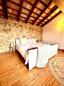 a bedroom with a bed and a stone wall at B&B La Vista Brava in Platja d'Aro