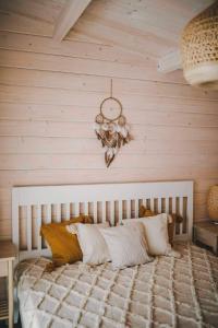 um quarto com uma cama grande e uma parede de madeira em Miško kraštas em Vileikiai