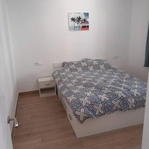a bedroom with a bed with a quilt on it at Apartamento primera línea de mar - cerca de Portaventura in Salou