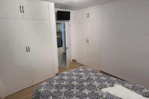 a bedroom with white cabinets and a bed in it at Apartamento primera línea de mar - cerca de Portaventura in Salou +2 photos