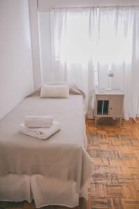 ein Schlafzimmer mit einem Bett mit zwei Handtüchern darauf in der Unterkunft Amplio departamento en Mitre 565 in Mendoza