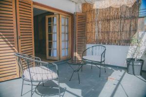 2 Stühle und ein Tisch auf der Terrasse in der Unterkunft Amplio departamento en Mitre 565 in Mendoza