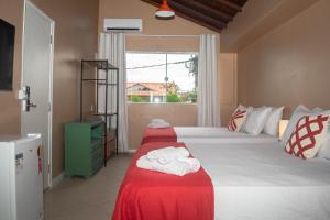 a bedroom with two beds and a window at Porteño Loft Búzios in Búzios