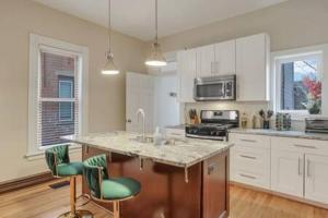 a kitchen with white cabinets and a marble counter top at Historic Elegance Retreat - Columbus Downtown in Columbus