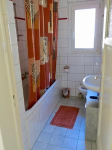 La salle de bains est pourvue d'une baignoire, d'un lavabo et d'une douche. dans l'établissement Chez Carole (4 pièces), à Neuchâtel