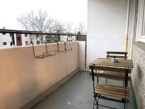 een balkon met een houten tafel en een bank bij LIME HOMES: Küche, Balkon, Netflix in Hildesheim