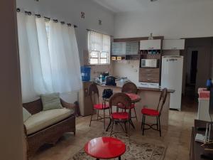 een keuken met een bank en een tafel en stoelen bij Casa com boas acomodações in Itanhaém