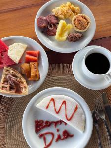 a table with plates of food and a cup of coffee at Terra Bella Pousada in Morro de São Paulo