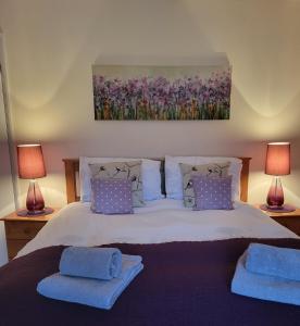 a bedroom with a bed with two blue towels on it at Grayz Townhouse - Free onsite parking for 2 cars in Lincoln