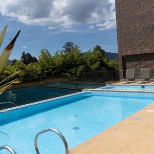 a large swimming pool with chairs and a building at Retirada in Rionegro