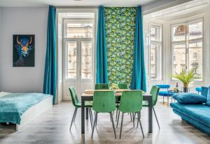 a dining room with a table and green chairs at Downtown Delight - Erzsébet BLVD - 13 PPL in Budapest