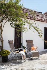 2 Stühle und ein Tisch vor einem Haus in der Unterkunft Casa Quintal da Aldeia in Alcobaça