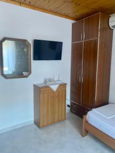 1 dormitorio con lavabo, cama y espejo en Panoramic View Guest House, en Gjirokastra
