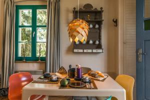 a dining room with a white table and orange chairs at Pommernhaus Josephinenhof, Sauna, Kamin, Ruderboot in Christianshof