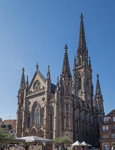 a large cathedral with a clock tower on top of it at Mulhouse, Urban Family Nest in Mulhouse