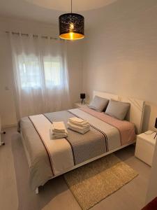 a bedroom with a bed with two towels on it at Apartamento Palomar in Pombal