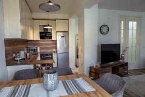 a kitchen and dining room with a table and chairs at White Apartment Prishtina in Pristina