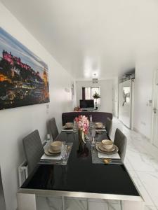 a dining room with a black table and chairs at Shared House - 10 mins from Piccadilly Station/Man Uni/O2 Apollo in Manchester