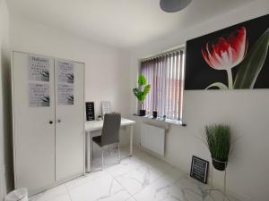 ein weißes Büro mit einem Schreibtisch und einer roten Blume an der Wand in der Unterkunft Shared House - 10 mins from Piccadilly Station/Man Uni/O2 Apollo in Manchester + 4 Fotos