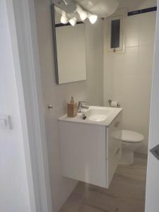 uma casa de banho branca com um lavatório e um WC em Apartamento en Binibeca Nou em Binibeca