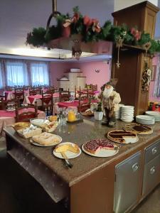 uma cozinha com uma mesa cheia de comida num balcão em ALBERGO AL LAGO em Imer