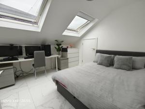 Schlafzimmer mit einem Bett und einem Schreibtisch mit einem Computer in der Unterkunft Shared House - 10 mins from Piccadilly Station/Man Uni/O2 Apollo in Manchester