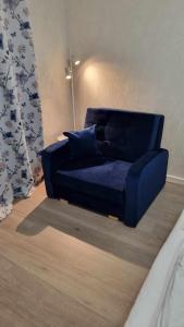 un sofá azul sentado en una sala de estar en Holiday apartment, en Kleppstad