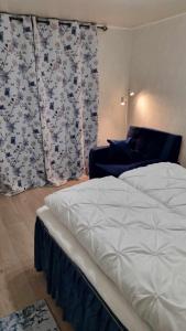 1 dormitorio con 1 cama y una ventana con cortinas en Holiday apartment, en Kleppstad
