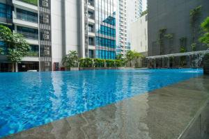 a large swimming pool in a city with tall buildings at Luxury & Bright 2BR Chianti Tower Mall Access in Jakarta
