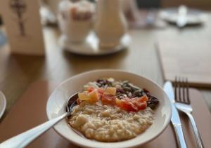 uma tigela de aveia com frutas e produtos hortícolas numa mesa em The Atholl Palace em Pitlochry