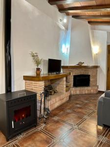 sala de estar con chimenea y TV en Alojamientos La Tercia, en Benizar