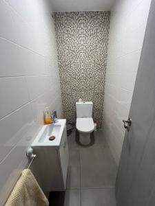 a small bathroom with a toilet and a sink at Apartamento Palomar in Pombal
