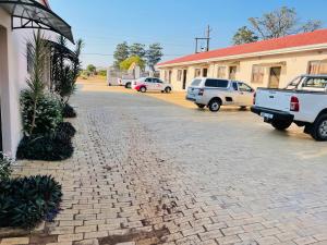 a street with cars parked in front of a building at SNORING INN Hlabisa in Hlabisa
