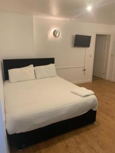 a bedroom with a large bed with white sheets at Crompton Haven, Liverpool Accessible Home in Liverpool