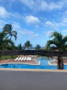 un complejo con una piscina con tumbonas y palmeras en Hotel Torre Molino, en Monte Gordo