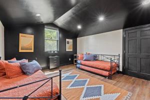 a bedroom with two beds and a black wall at New Barndo/Kayak Launch/ 2 Private Hot Tubs in Stanton