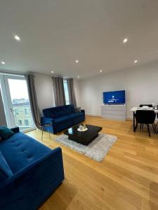 - un salon avec un canapé bleu et une table dans l'établissement Bright two bedrooms apartment, à Londres