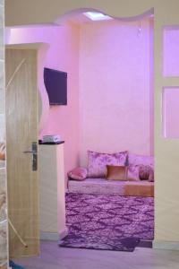 阿尤恩的住宿－Saffana Sahara Stay，紫色的客房配有沙发和电视