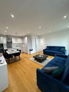 - un salon avec un canapé bleu et une table dans l'établissement Bright two bedrooms apartment, à Londres