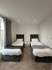 ロンドンにあるBright two bedrooms apartmentのベッド3台が並ぶ客室です。