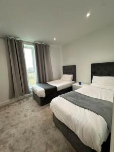- une chambre avec 2 lits et une fenêtre dans l'établissement Bright two bedrooms apartment, à Londres