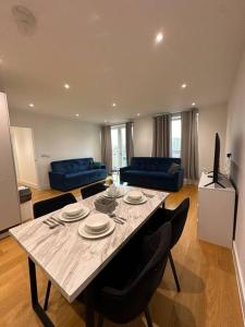 - un salon avec une grande table en bois et des chaises dans l'établissement Bright two bedrooms apartment, à Londres