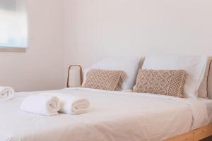 a white bed with towels on top of it at Casa Quintal da Aldeia in Alcobaça