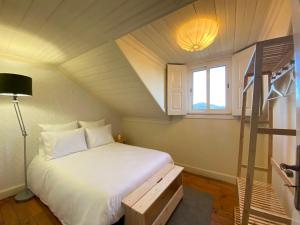 a bedroom with a white bed and a window at Casa dos Frades in Vinhais