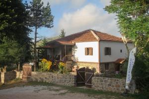 una pequeña casa blanca con una pared de piedra en TAŞ KONAK BUTİK OTEL, en Ordu