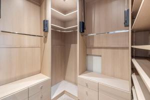 a walk in closet with wooden cabinets and shelves at Mansion with jacuzzi in London 7 min from Station in London