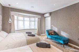 a bedroom with two beds and a blue couch at Mansion with jacuzzi in London 7 min from Station in London
