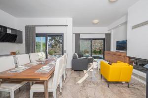 a dining room with a wooden table and yellow chairs at Villa Al Mare 2; Koyunbaba'da Özel Havuzlu Villa in Bodrum City