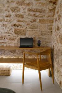 a wooden desk with a laptop on a brick wall at Lindas Convent Garden Home 1 in Chania Town