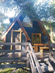 Cabaña de madera con porche de madera y puerta en COEMBOTA Cabañas en Tigre